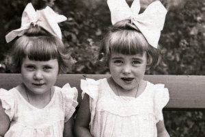 > két kislány masnival a hajukban néznek a kamerába